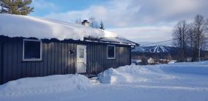 LjørdalFulufjellet的屋顶上积雪的小房子