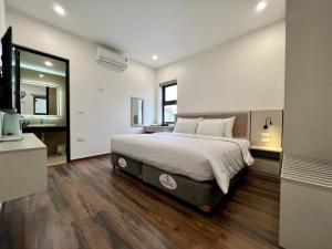 河内Grand Dragon Noi Bai Hotel的一间卧室设有一张大床和一个大镜子