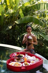 芭东海滩Three Monkeys Villas的坐在游泳池里带餐盘的女人