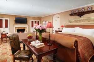 厄维召特Summer Lodge Country House Hotel的一间卧室配有一张床和一张沙发桌子
