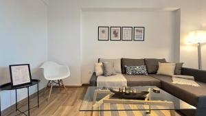 雅典Pentelis Cozy 58sqm apt in Paleo Faliro的客厅配有沙发和桌子