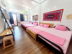 朱笃Homestay Khoa Chaudoc的配有粉红色床单的客房内的两张床