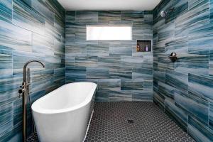 迪凯特East Atlanta / Decatur retreat with fire-pit的浴室设有白色浴缸和蓝色瓷砖