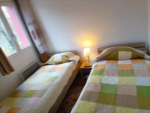 弗兰奎维尔-圣皮尔Charmante Maisonnette indépendante avec parking 5 mn Rouen的一间卧室设有两张床和窗户。