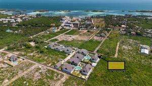 瓦塔穆Nadia&Ale House - Maisha Resort的享有村庄的空中景致,设有房屋和海洋