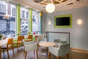 巴黎圣乔治拉法耶特酒店的一间带桌椅和电视的餐厅