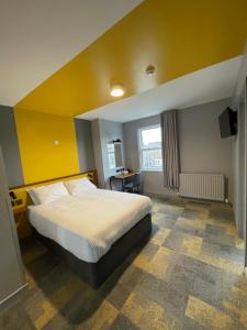 都柏林菲茨西蒙斯圣殿酒吧酒店的一间卧室设有一张床和黄色的墙壁