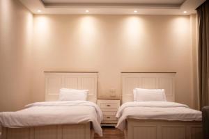 开罗Munir’s residence的客房内的两张床、白色的毯子和枕头