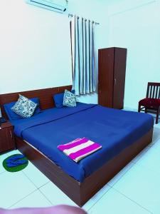 斋浦尔Hotel S-14的一间卧室配有一张带蓝色床单的床和一把椅子