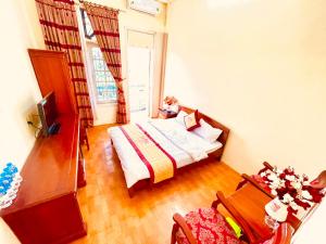 Xuân ÐàiLam Hong Hotel的卧室配有1张床、1张桌子和1把椅子