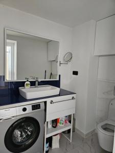 巴统Orbi apartament的一间带洗衣机和水槽的浴室