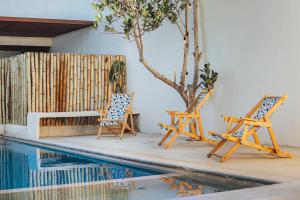 拉曼萨尼亚Discover La Manzanilla: New Natural Haven for Adventure的游泳池畔的两把椅子和一张桌子
