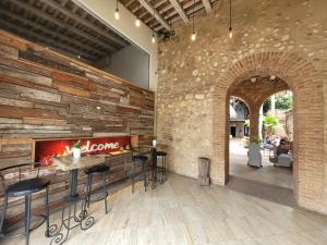 圣多明各Heritage Residences Signature Collection的一间石墙餐厅和一间带凳子的酒吧