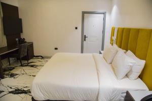 拉各斯The Safron Hotel的卧室配有一张白色大床和一张书桌