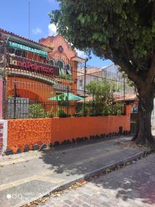 萨尔瓦多Pousada San Salvador的一座建筑前有树的橙色围栏