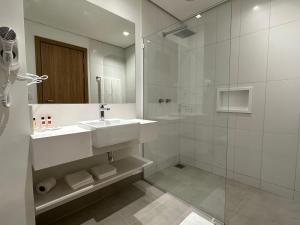 瓜鲁柳斯帕纳比瓜鲁柳斯酒店的白色的浴室设有水槽和淋浴。