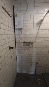曼谷Chubby 9 Room 7的浴室设有白色瓷砖墙壁和淋浴。