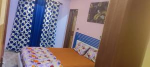 瓦加杜古Passion RÉSIDENCE的一间小卧室,配有床和蓝色窗帘