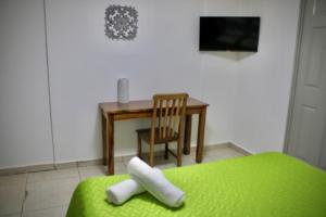 圣萨尔瓦多Villa Stahl的配有床、桌子和电视的房间