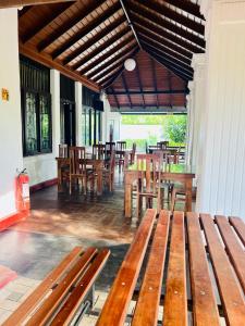 康提Sadamadala Guest House Kandy的庭院设有木长椅和桌椅