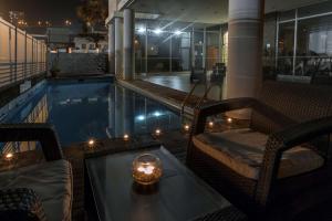 安托法加斯塔安托法加斯塔NH酒店的一个带桌椅和蜡烛的游泳池