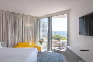马赛马赛豪酒店的酒店客房设有黄色椅子和大窗户