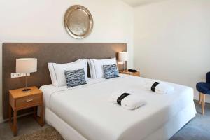 拉戈斯蒂沃利拉各斯酒店的卧室配有一张白色大床和镜子