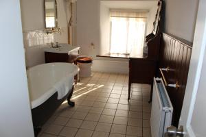 RisleyRisley Hall Hotel的带浴缸、水槽和窗户的浴室