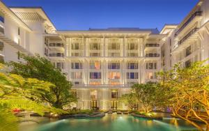 曼谷Hua Chang Heritage Hotel的一座大型建筑,前面设有一个游泳池