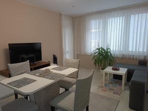 戈采代尔切夫City Apartment的客厅配有桌椅和电视。