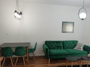 奥瓦瓦Oława Jodłowa的客厅配有绿色沙发和椅子