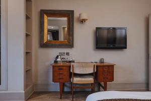 伦敦斯托克纽因顿玫瑰和皇冠旅馆的酒店客房设有一张带镜子的书桌和一台电视机