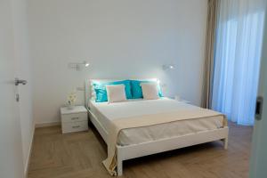 维拉西米乌斯Estia Suites的一间卧室配有一张带蓝色枕头的大床