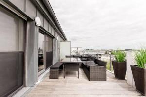 SandweilerLuminous Penthouse with Open Sky Terrace的大楼内的阳台配有沙发和桌子
