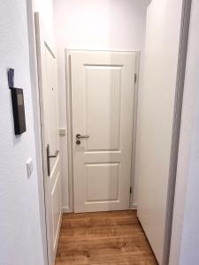 卡尔斯鲁厄Modernes Apartment im Zentrum von Karlsruhe的走廊上的白色门,铺有木地板