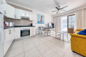 卡门港Casa Appia-300m from the beach, heated pool的厨房以及带桌子和沙发的客厅。