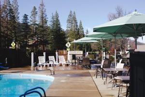 阿什兰艾希兰旗舰酒店的一个带桌椅和遮阳伞的游泳池