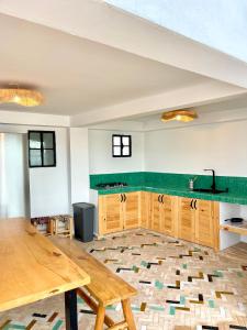 丹吉尔Socco Hostel的厨房配有木桌和绿色台面