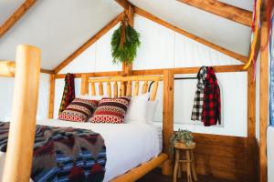 卡纳纳斯基斯村Sundance By Basecamp的一间卧室配有带枕头的木床