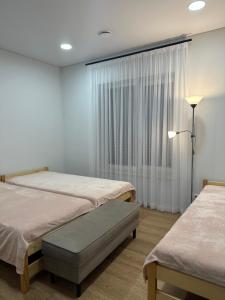克莱佩达Villa PANDA HOUSE in Klaipeda的一间医院间,设有两张床和窗户