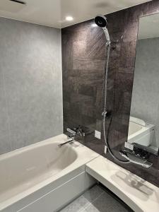 池田雷夫特大阪机场酒店的设有带浴缸和淋浴的浴室。