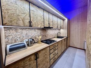 塞凡Milenium magic villa on Sevan beach的厨房配有木制橱柜和台面