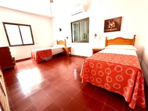 埃斯卡洛Villa Skiba Es Caló Formentera的一间卧室设有一张床,铺有红色地板
