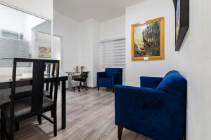 瓜达拉哈拉欧洲时尚行政套房酒店的客厅配有桌子和蓝色椅子
