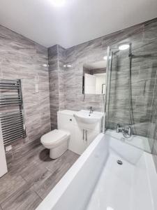 伍尔弗汉普顿Elegant City Apt: 1-BR Luxury的浴室配有盥洗盆、卫生间和浴缸。