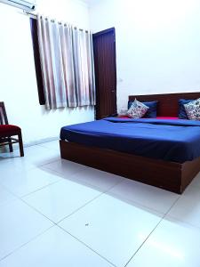 斋浦尔Hotel S-14的一间卧室配有一张带蓝色床单的大床