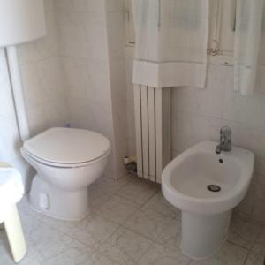 皮特拉利古Hotel La Milanese的白色的浴室设有卫生间和坐浴盆。