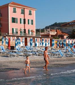 皮特拉利古Hotel La Milanese的海滩上散步的男人和孩子