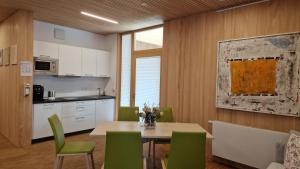 奥贝里德Barrierefreies Apartment Ursulinenhof的厨房以及带桌子和绿色椅子的用餐室。