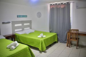 圣萨尔瓦多Villa Stahl的一间卧室配有两张带绿色床单和毛巾的床。